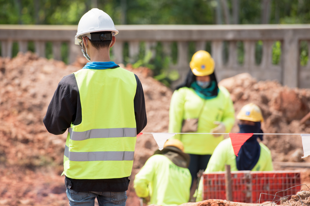 Construction site with workers wearing safety green