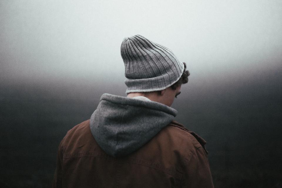 Man wearing wool hat and grey hoodie