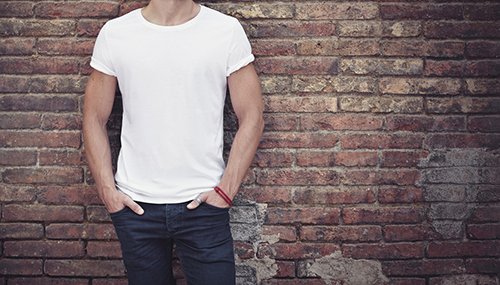 man wearing blank white t shirt brick wall