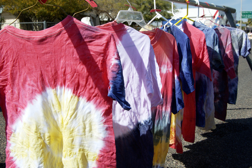 tie dyed shirts drying on hangers