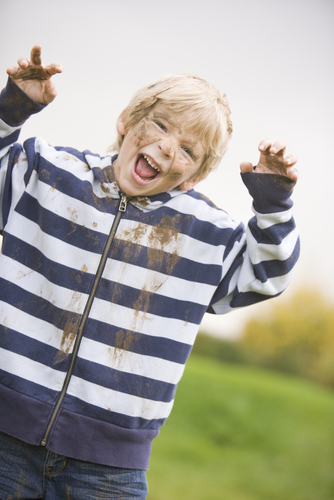 young boy covered in mud